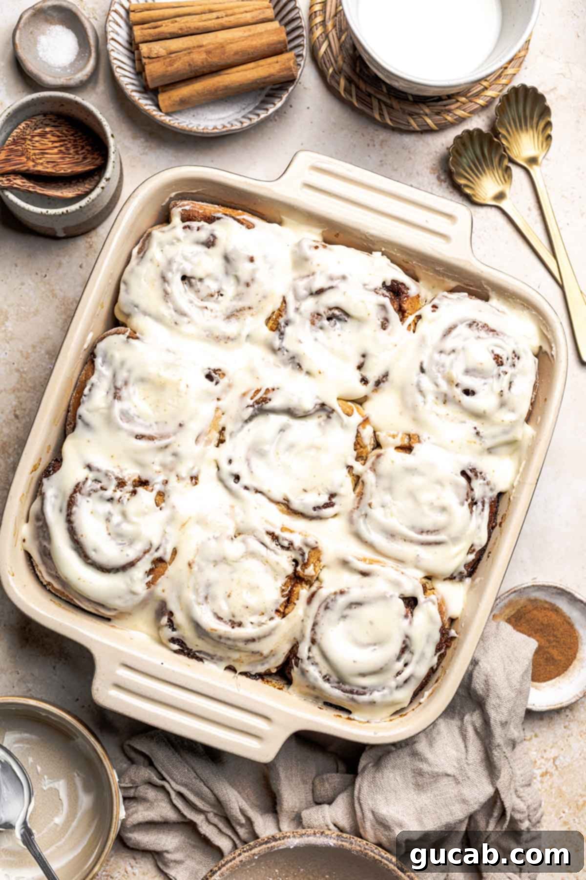Irresistible Gluten-Free Cinnamon Rolls 2 A baking dish filled with homemade gluten-free cinnamon rolls, generously topped with smooth cream cheese frosting, ready to be served.