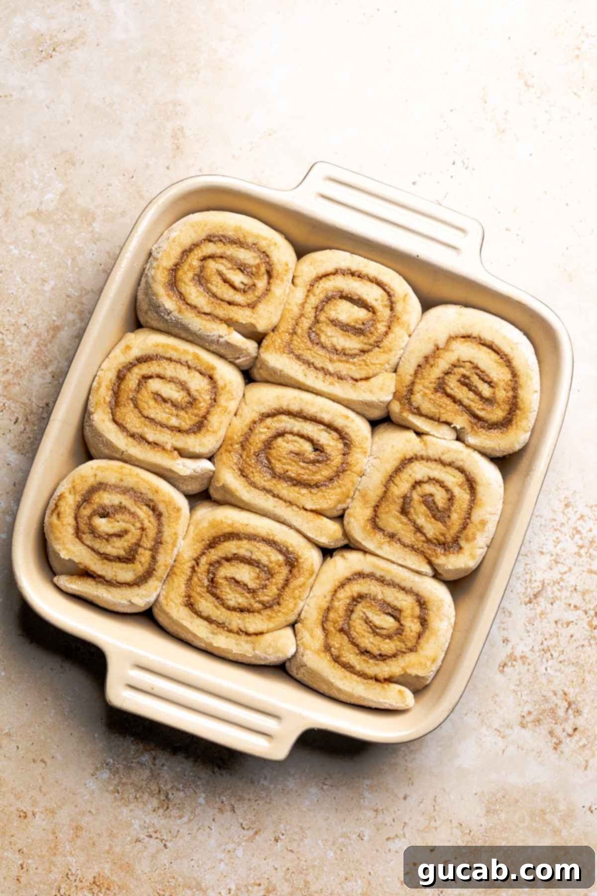 Irresistible Gluten-Free Cinnamon Rolls 20 Gluten-free cinnamon rolls after their second rise in the baking dish, appearing puffy and ready for the oven.