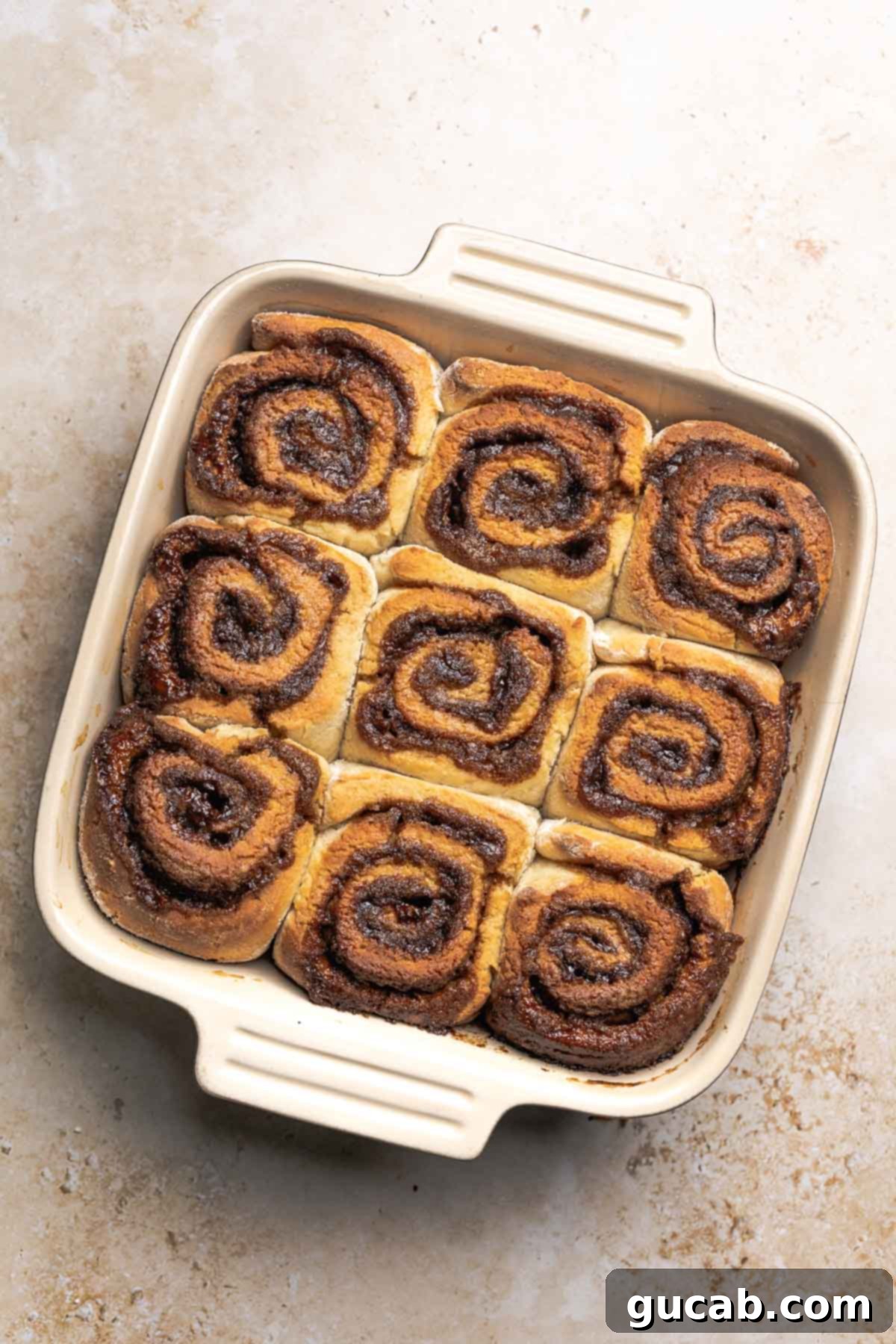 Irresistible Gluten-Free Cinnamon Rolls 21 Freshly baked gluten-free cinnamon rolls in a baking dish, golden brown on top and still warm from the oven.