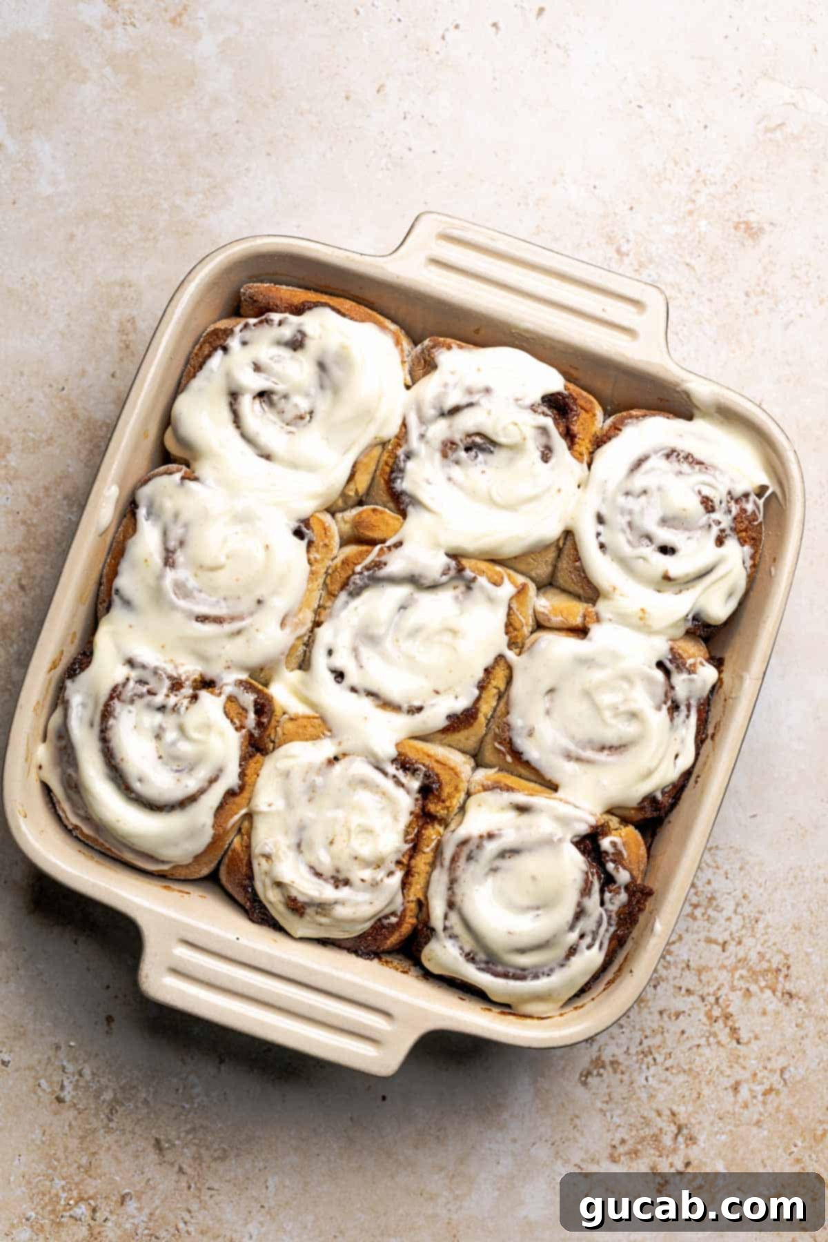 Irresistible Gluten-Free Cinnamon Rolls 23 A pan of freshly baked gluten-free cinnamon rolls, generously covered with a smooth layer of cream cheese frosting.