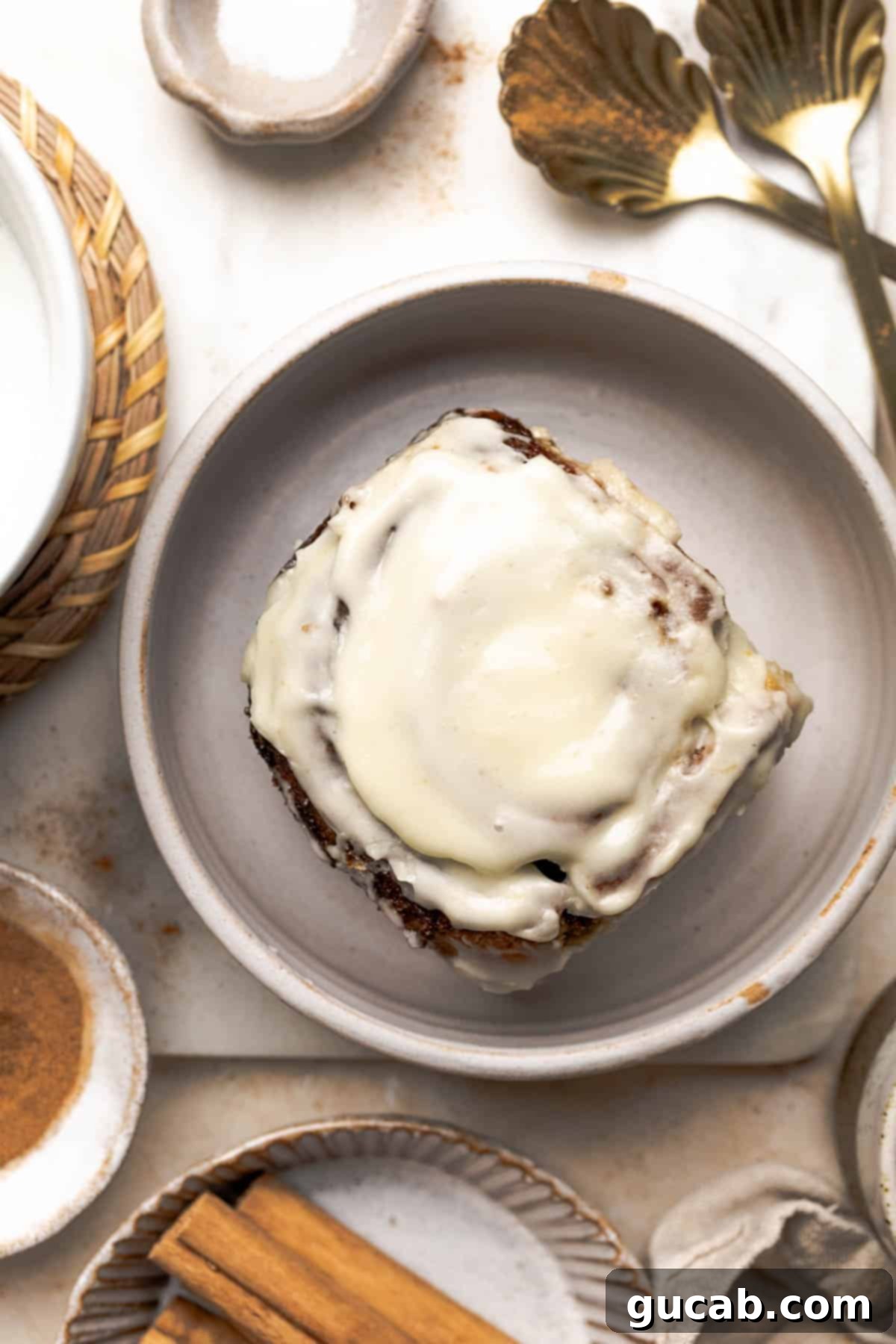 Irresistible Gluten-Free Cinnamon Rolls 25 A single, perfectly baked gluten-free cinnamon roll with cream cheese frosting, presented on a white plate, ready to be enjoyed.