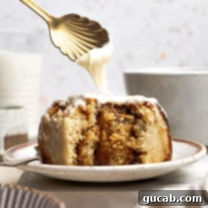 Irresistible Gluten-Free Cinnamon Rolls 26 A close-up image of a spoon drizzling luscious cream cheese frosting over a warm, soft gluten-free cinnamon roll, showcasing its delightful texture and the generous topping.