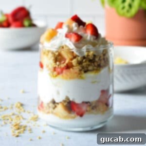 A vibrant and refreshing yogurt parfait featuring layers of strawberries, pineapple, and crunchy granola, ready to be enjoyed.