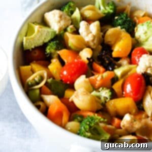 Dawn's Delightful Plant-Based Pasta Toss 7 a large bowl of vegetable pasta salad with tomatoes, bell peppers, and broccoli.