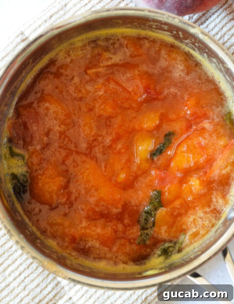 a pot with cooked peaches and basil in it. 