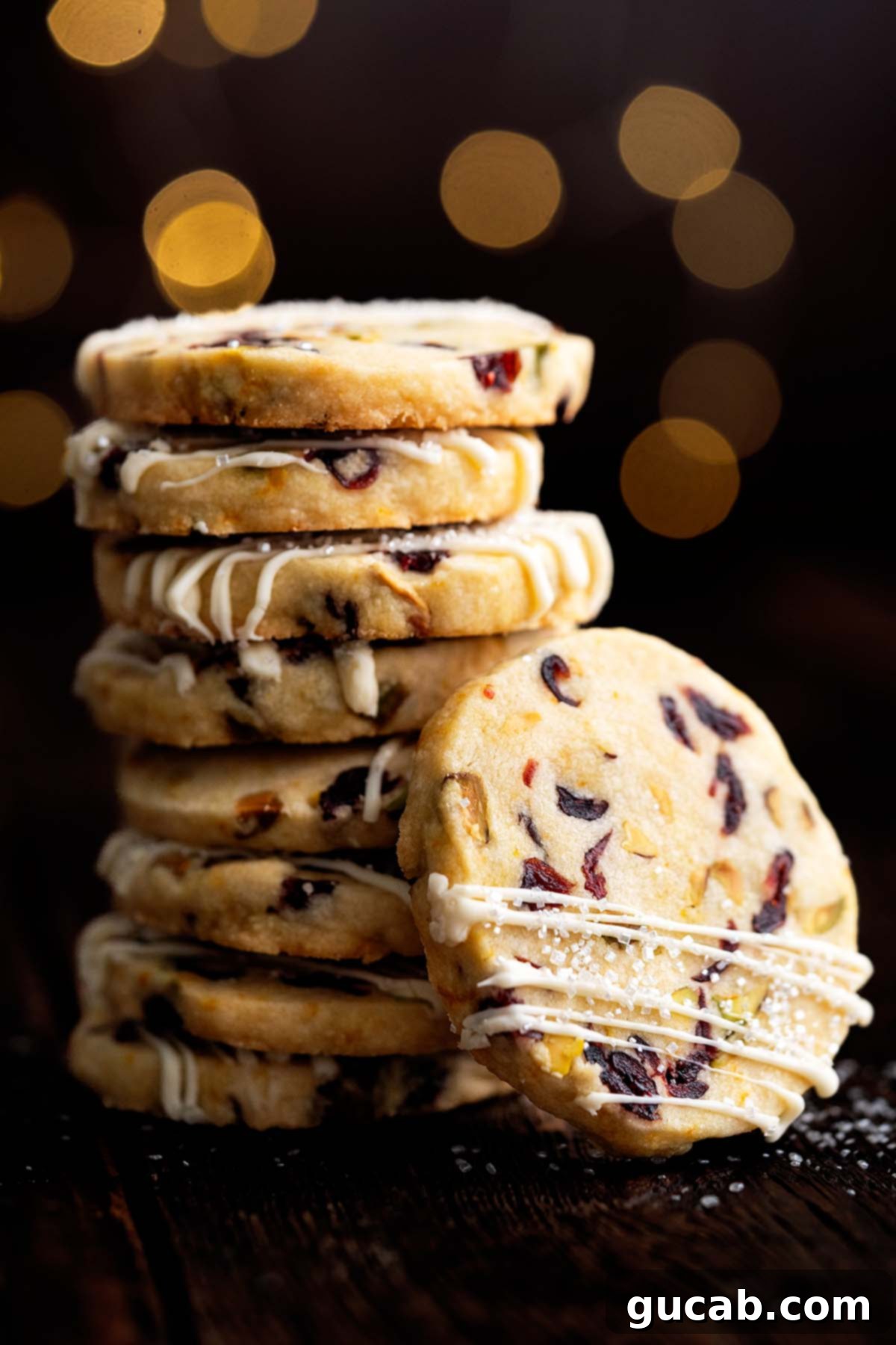 a stack of shortbread cookies with dried cranberries and pistachios in them. 