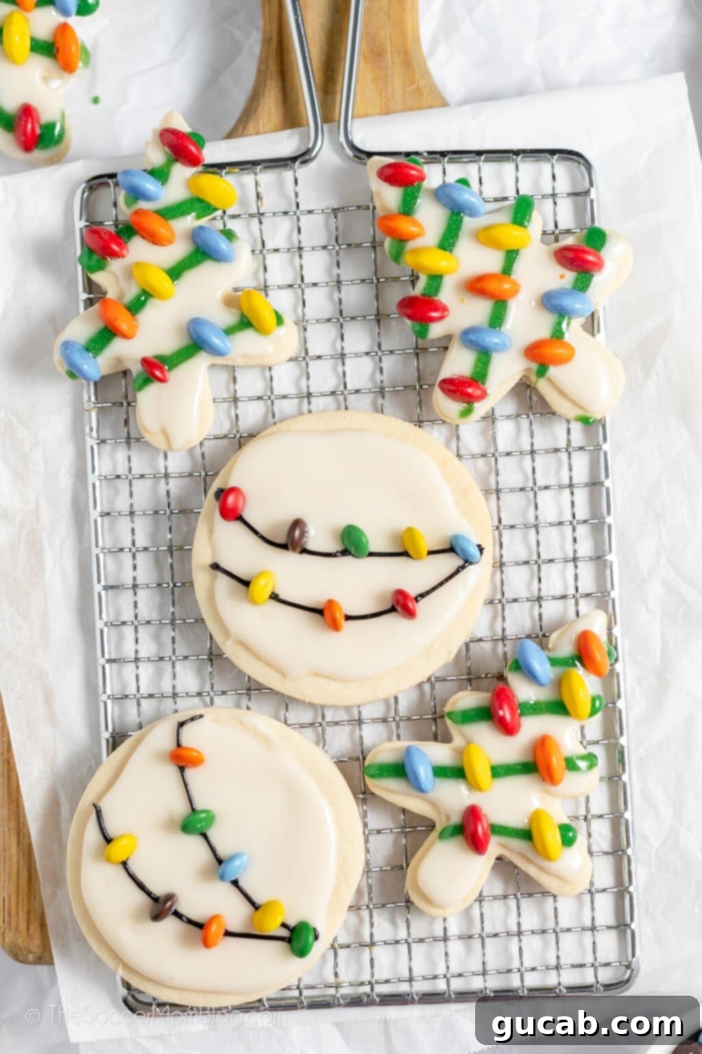 cookies with M&M's that look like christmas lights on a wire rack. 
