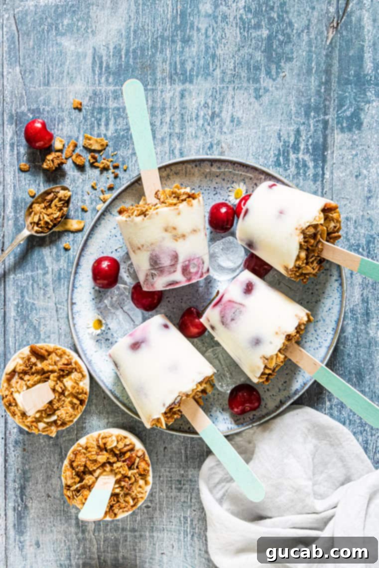 a plate with cherry yogurt and granola popsicles.