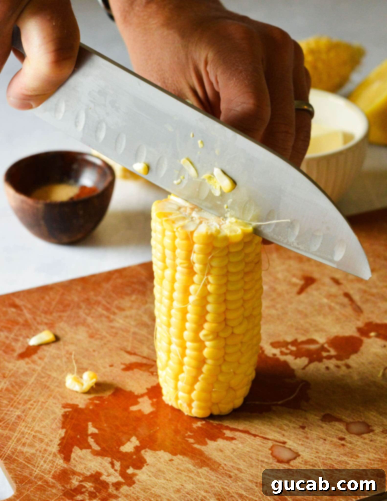 knife cutting into a standing corn cob