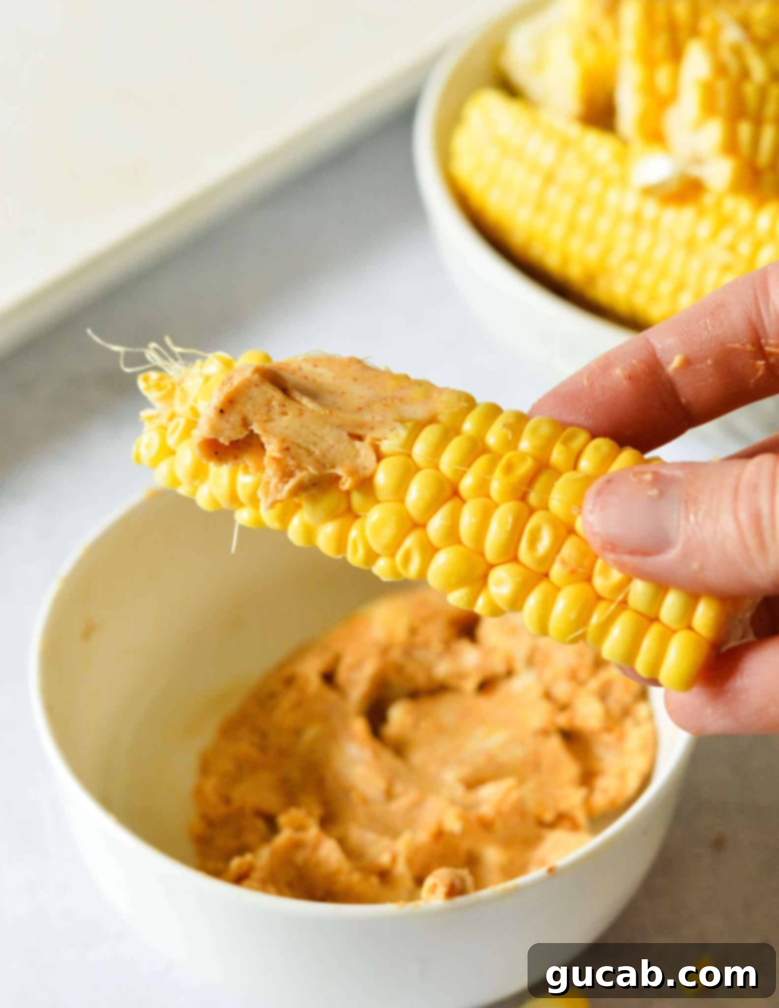 hand holding a corn rib with butter on it.