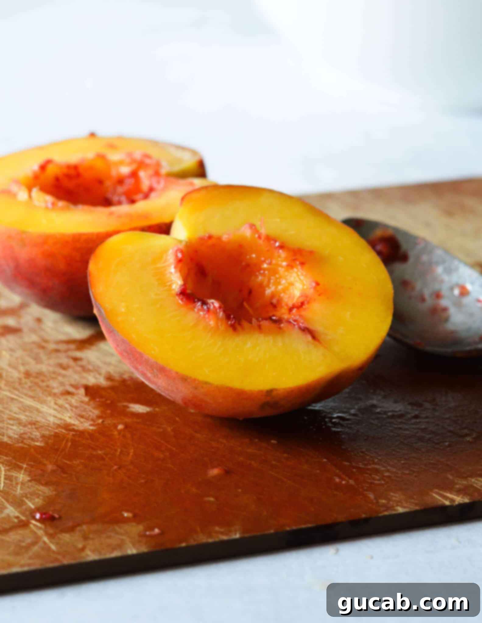 A peach half with the red, fibrous middle section neatly scooped out.