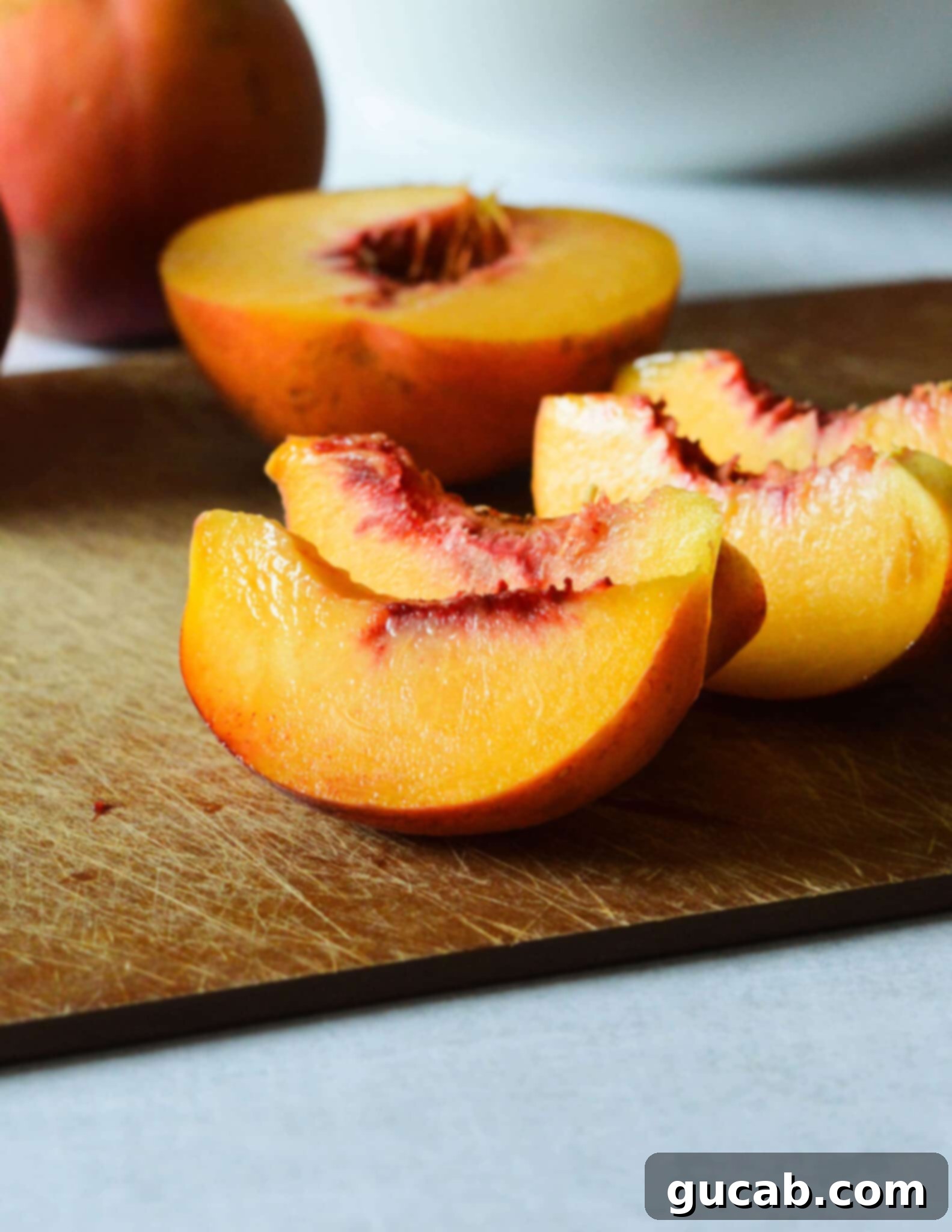 Neatly cut peach slices arranged on a clean cutting board.