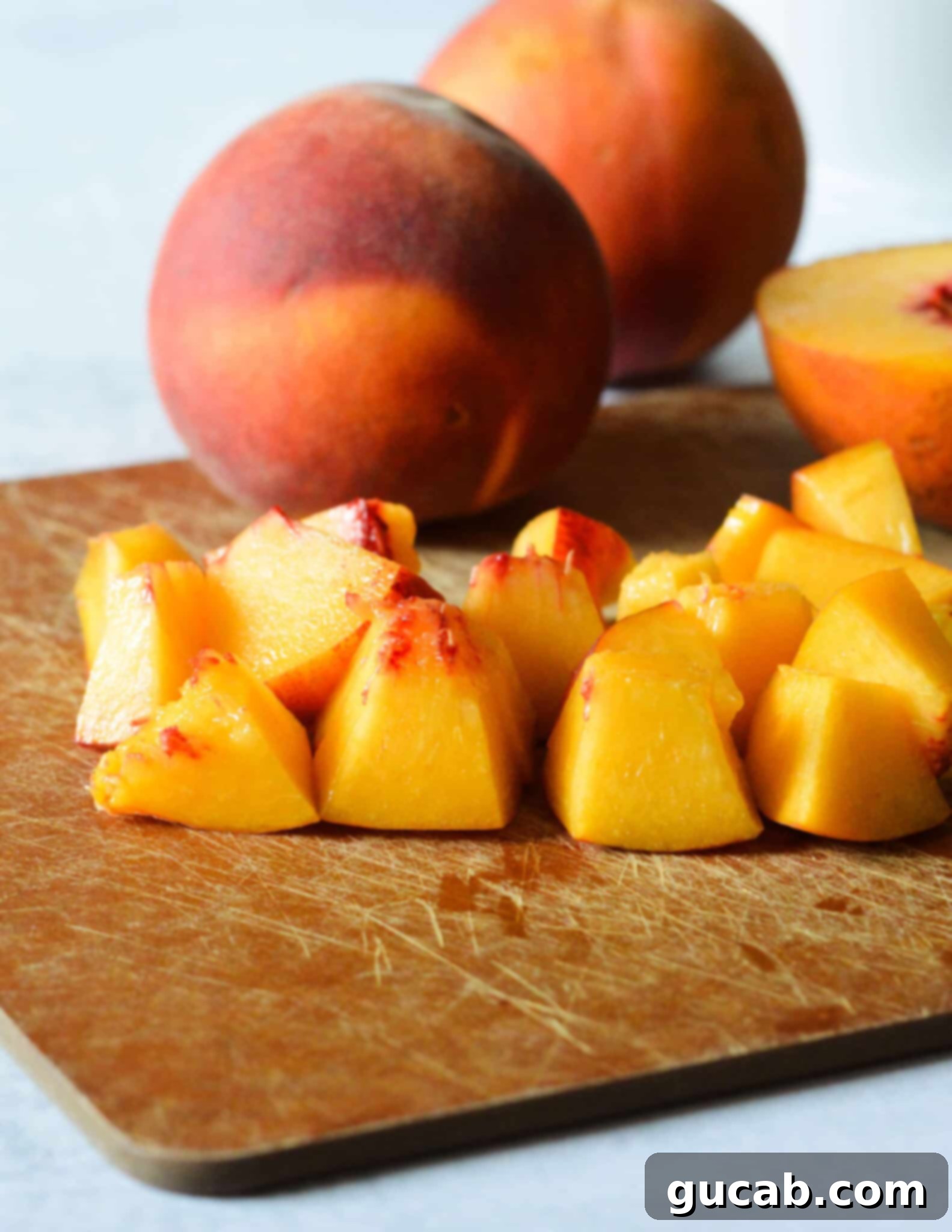 Uniformly diced peaches neatly piled on a cutting board, ready for the salad. 
