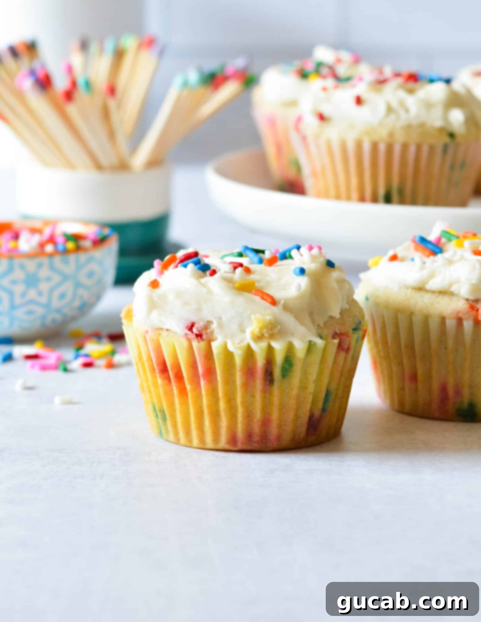 Gluten-free funfetti cupcakes with colorful jimmies on top, ready for a celebration.
