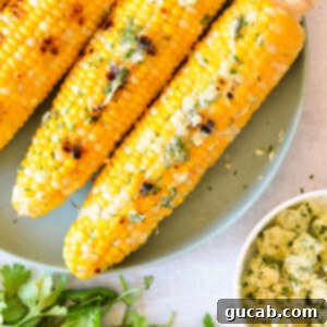 grilled corn on the cob with lemon herb butter on a plate