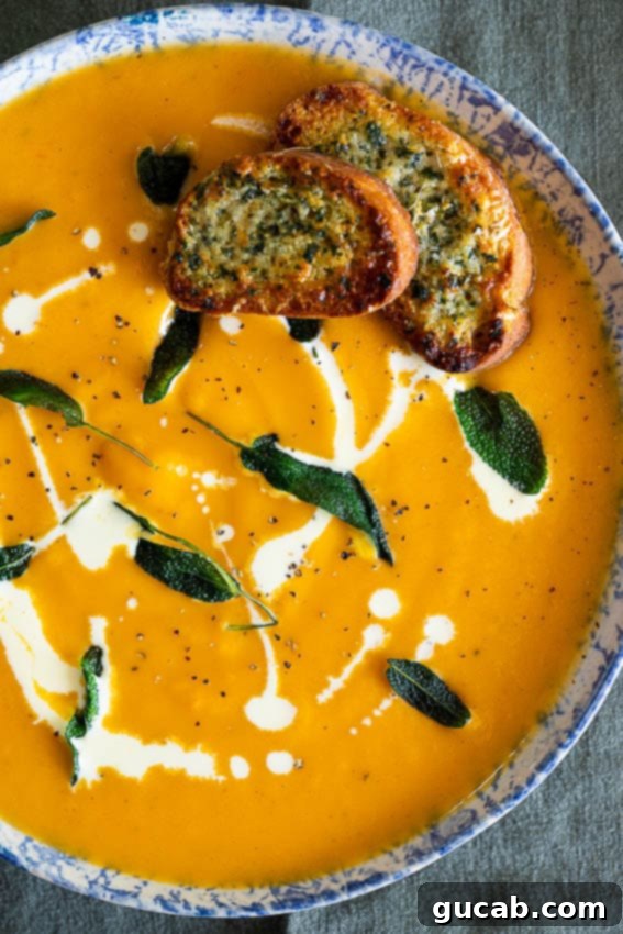 A bowl of creamy sweet potato soup, beautifully topped with crispy parmesan croutons or toasts.