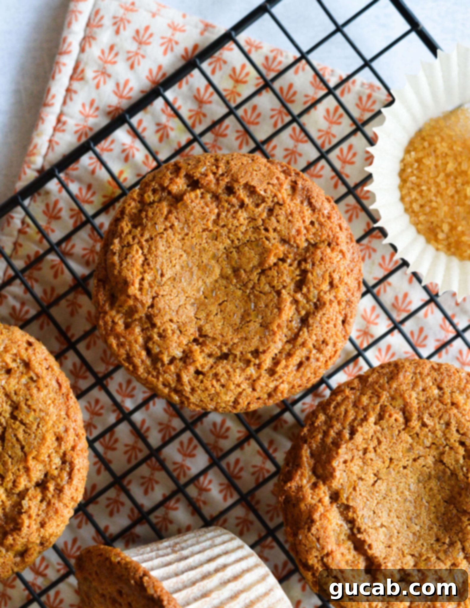 the tops of gingerbread muffins on a wire rack. 