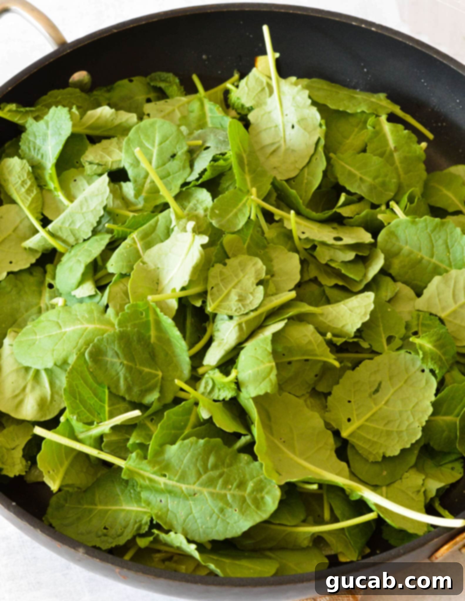 Fresh baby kale, sliced leeks, and minced garlic sautéing in a hot nonstick skillet, releasing their fragrant aromas.
