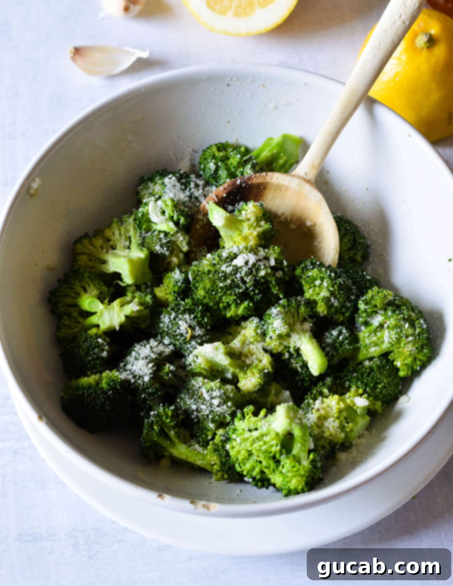 Easy 10-Minute Garlic Butter Broccoli 2 A bowl of vibrant green garlic butter broccoli generously topped with grated Parmesan cheese.