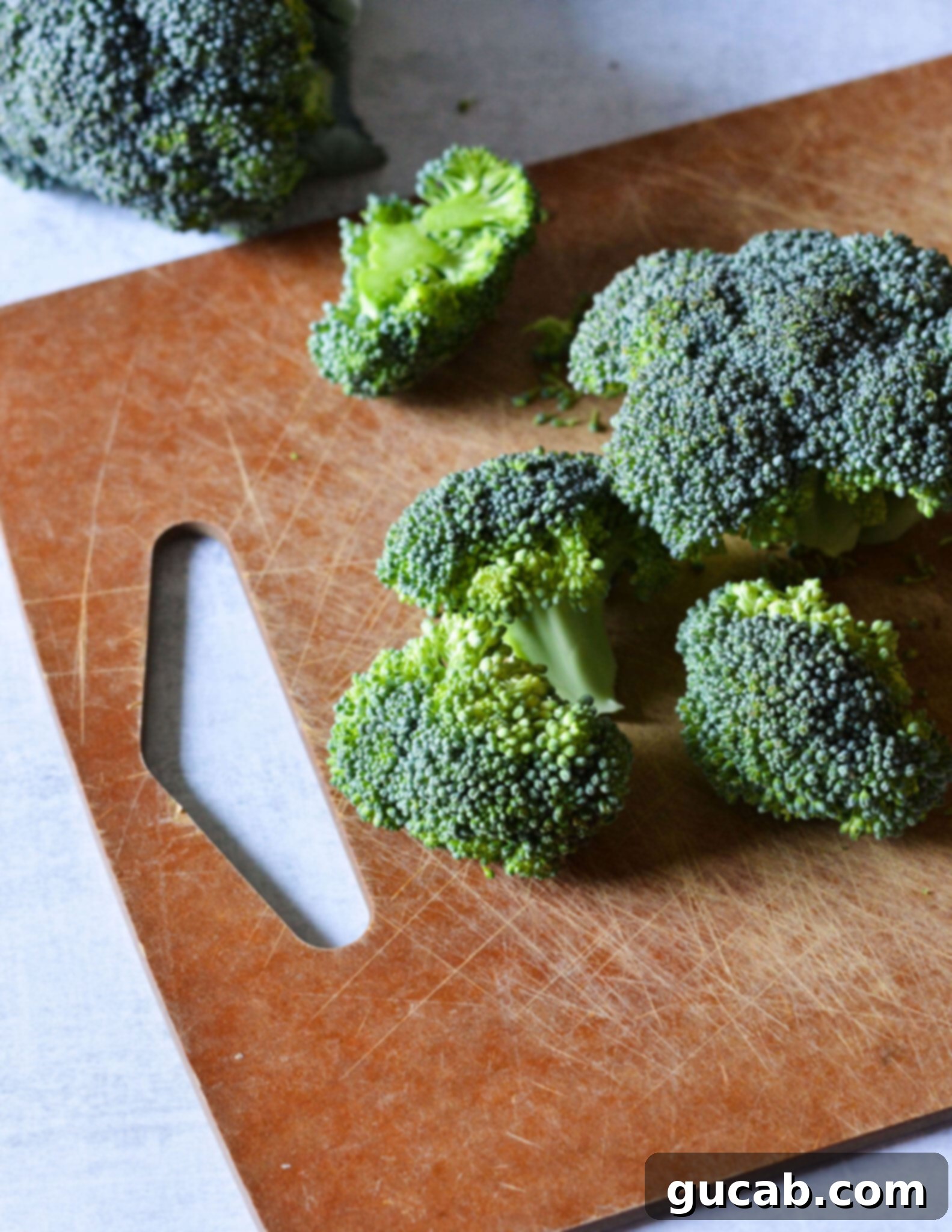 Easy 10-Minute Garlic Butter Broccoli 4 Fresh broccoli florets neatly arranged on a wooden cutting board, ready for preparation.