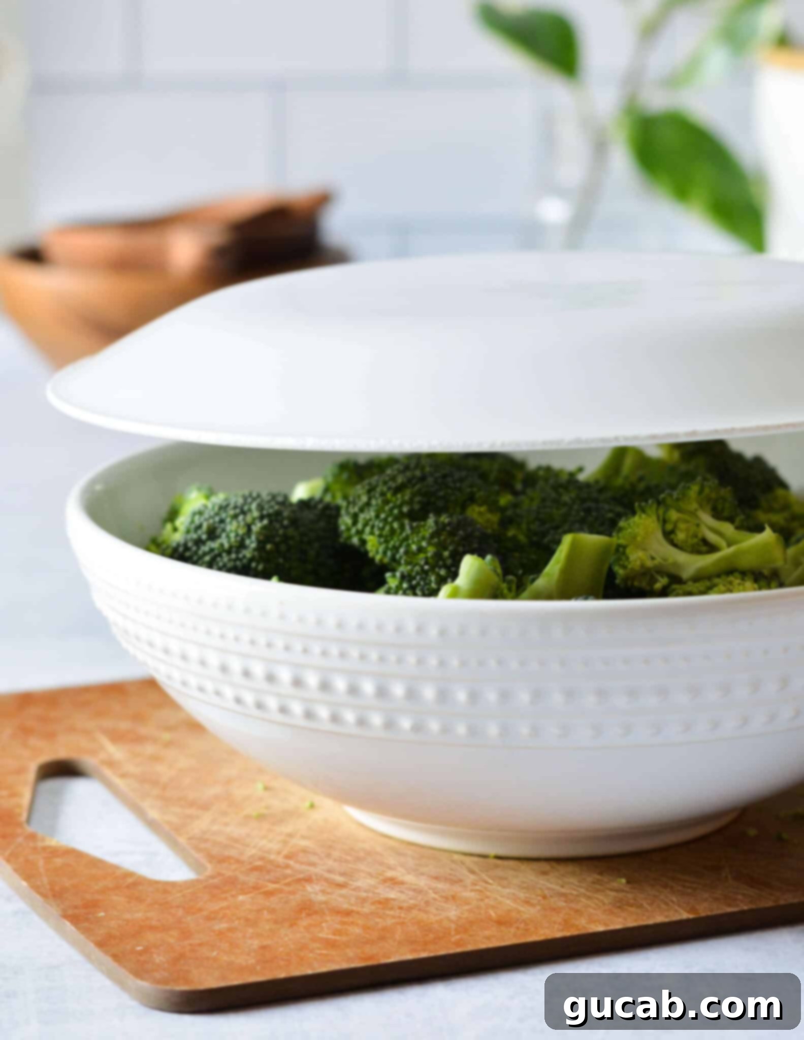 Easy 10-Minute Garlic Butter Broccoli 9 A bowl of broccoli florets covered with a microwave-safe plate, prepared for steaming.