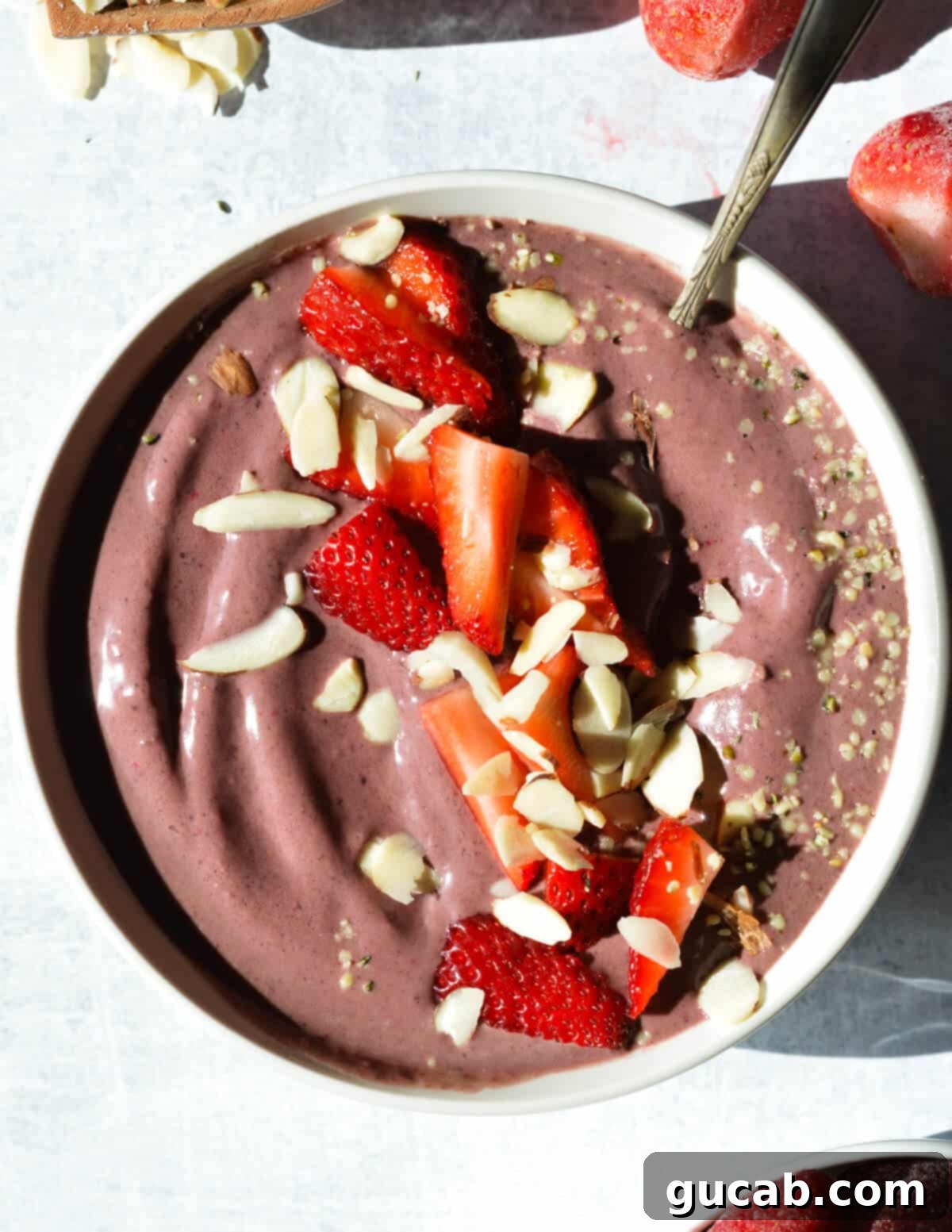 acai smoothie bowl with quartered strawberries, sliced almonds, and hemp hearts on top. 