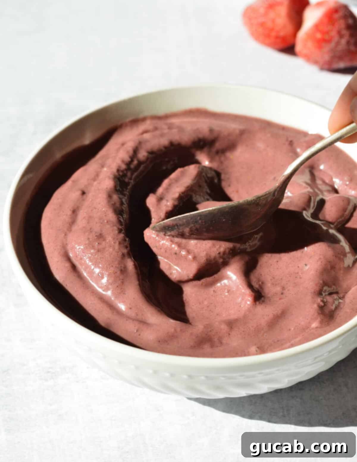 spoon smoothing out an acai smoothie bowl. 