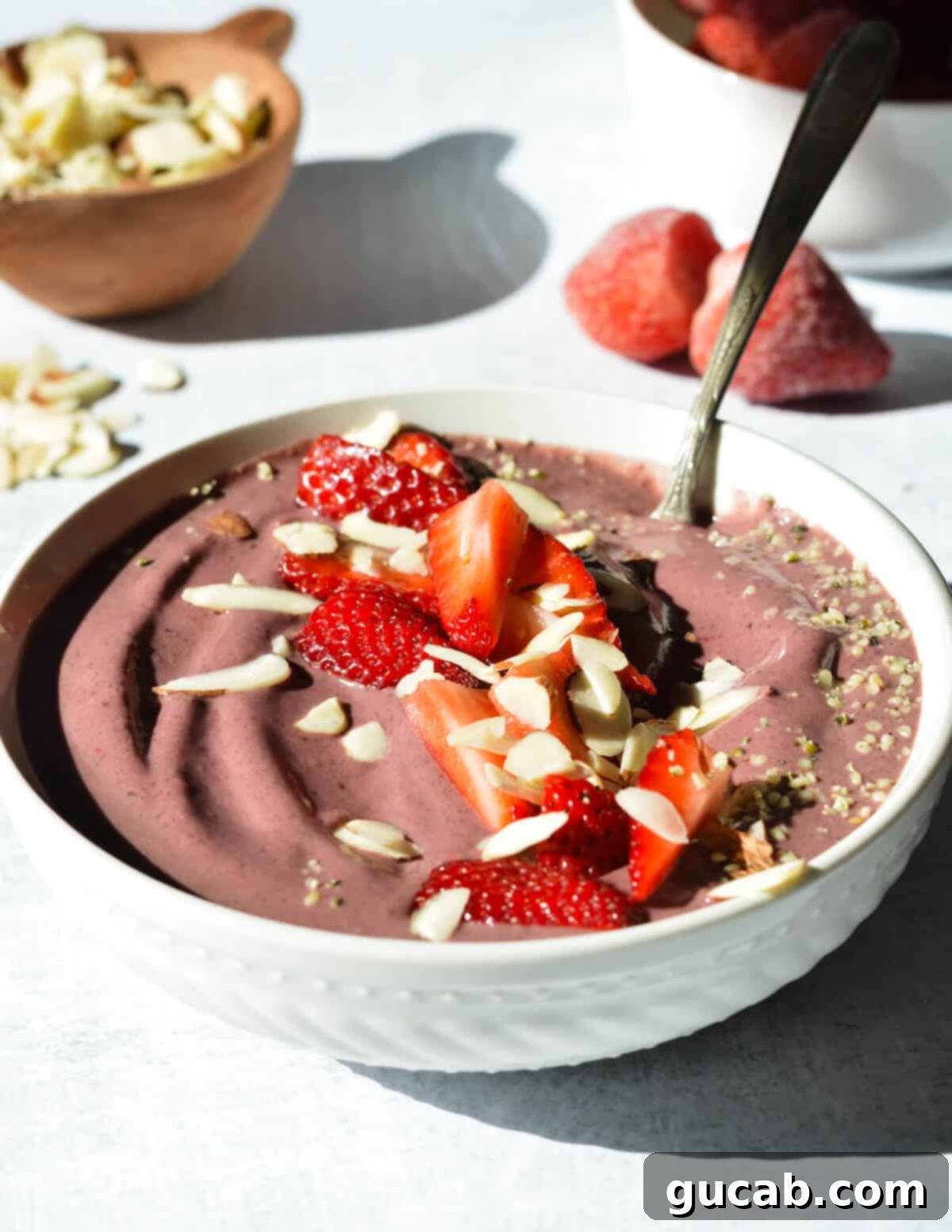 Protein Packed Acai Bowl 9 an acai bowl with strawberries, sliced almonds, and hemp hearts on top.