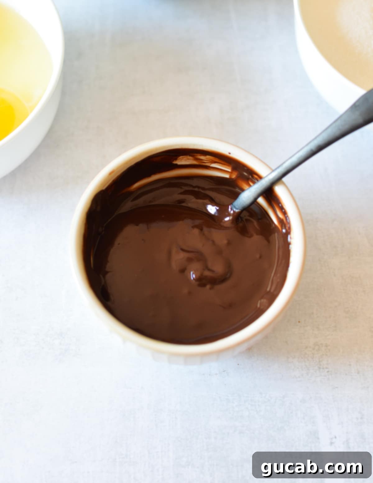 A small bowl of perfectly melted chocolate, ready to be swirled into the pumpkin batter.
