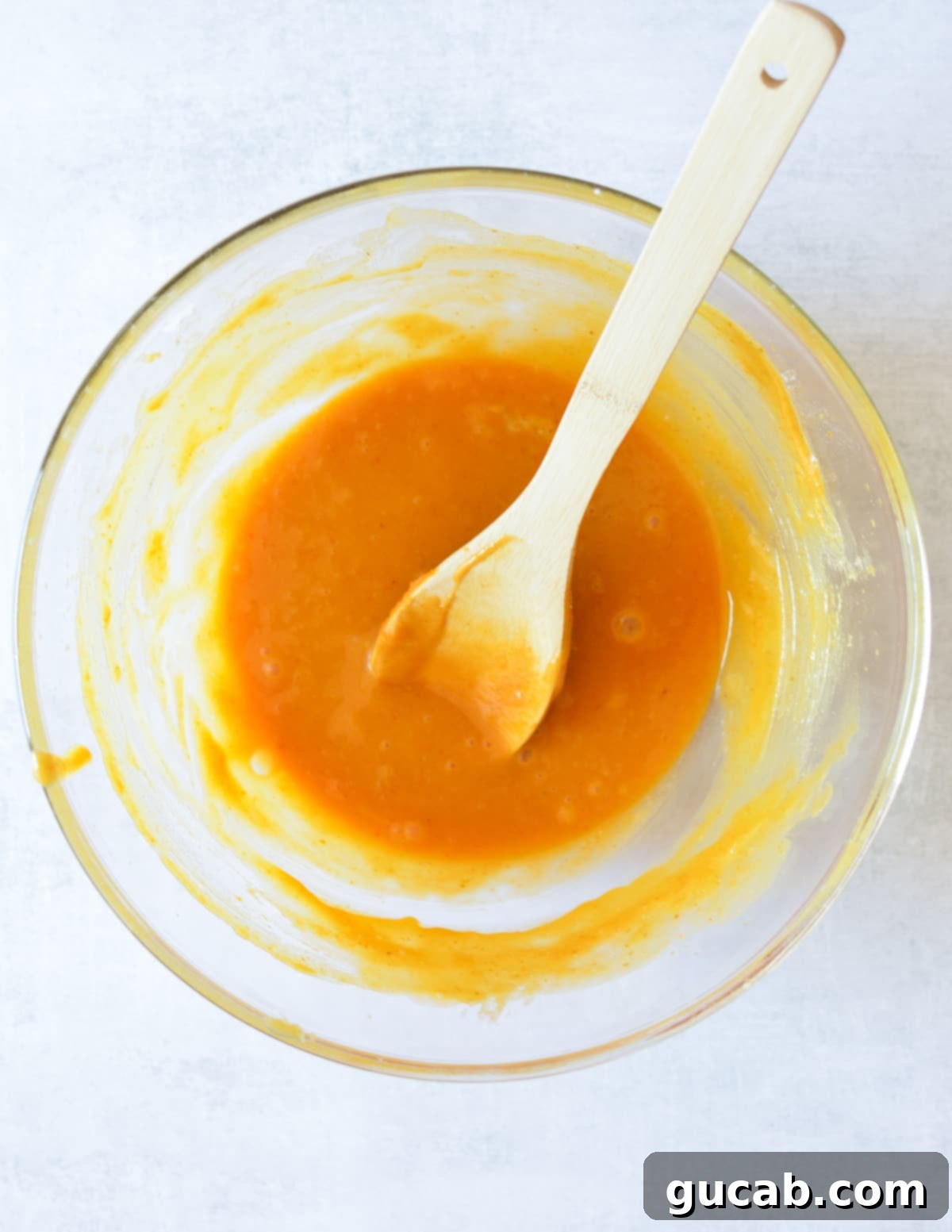 The pumpkin, sugars, and oil expertly mixed together into a smooth, vibrant orange batter base.