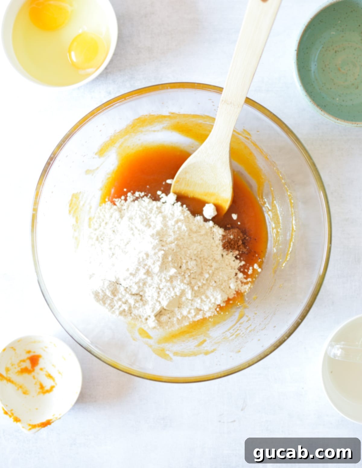 A bowl of pumpkin mixture with a mound of gluten-free flour and spices resting on top.