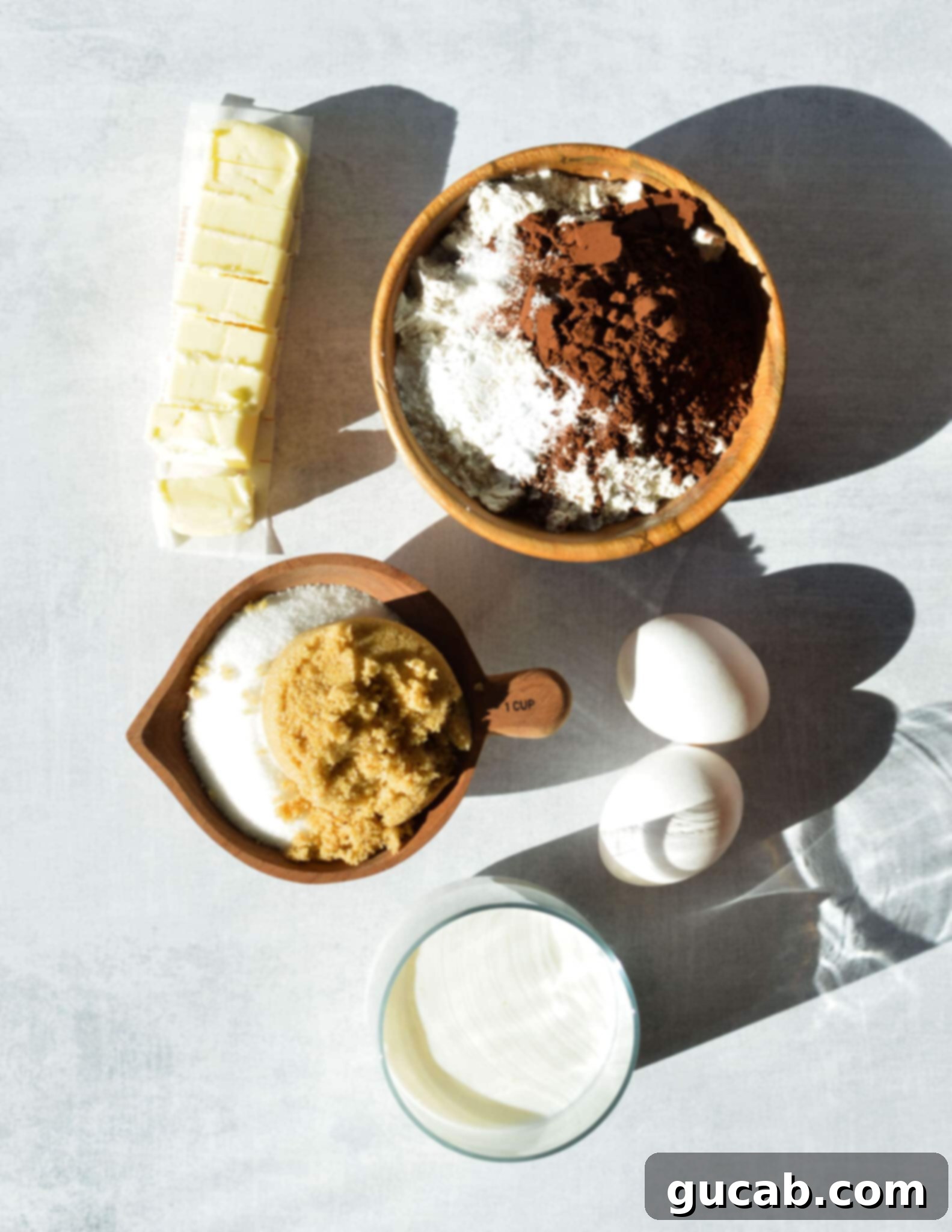sliced stick of butter, gluten free flour, cocoa powder, sugar, brown sugar, and eggs.