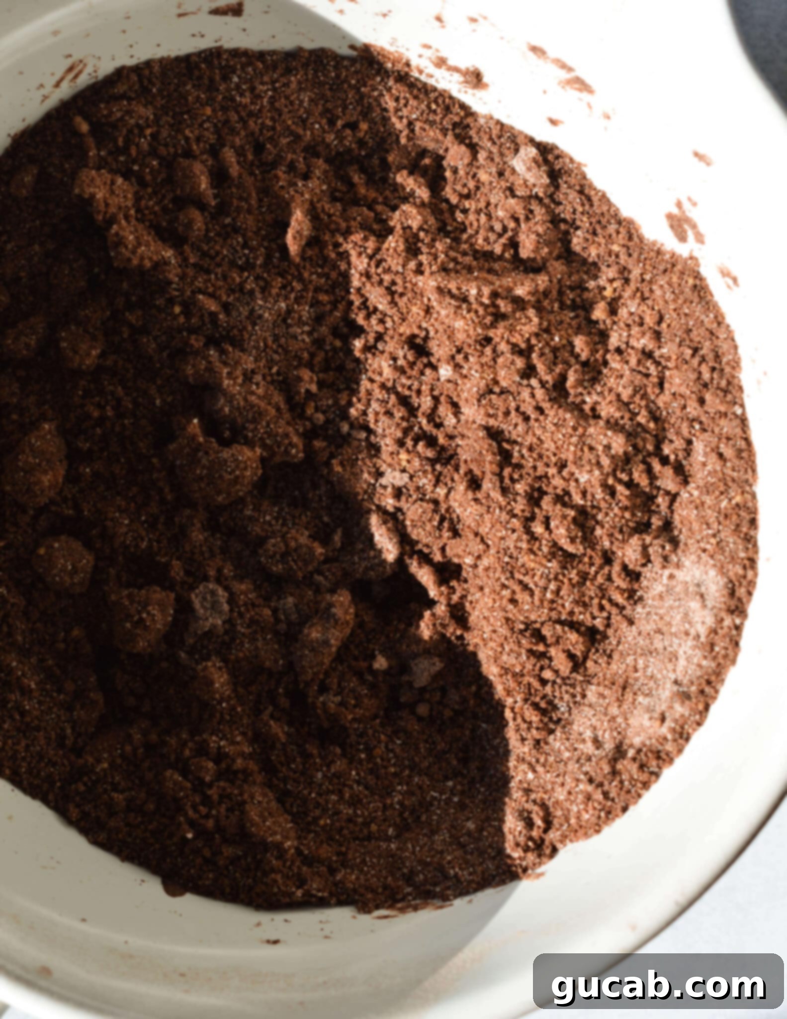 butter mixed into flour, sugar, and cocoa powder in a bowl.