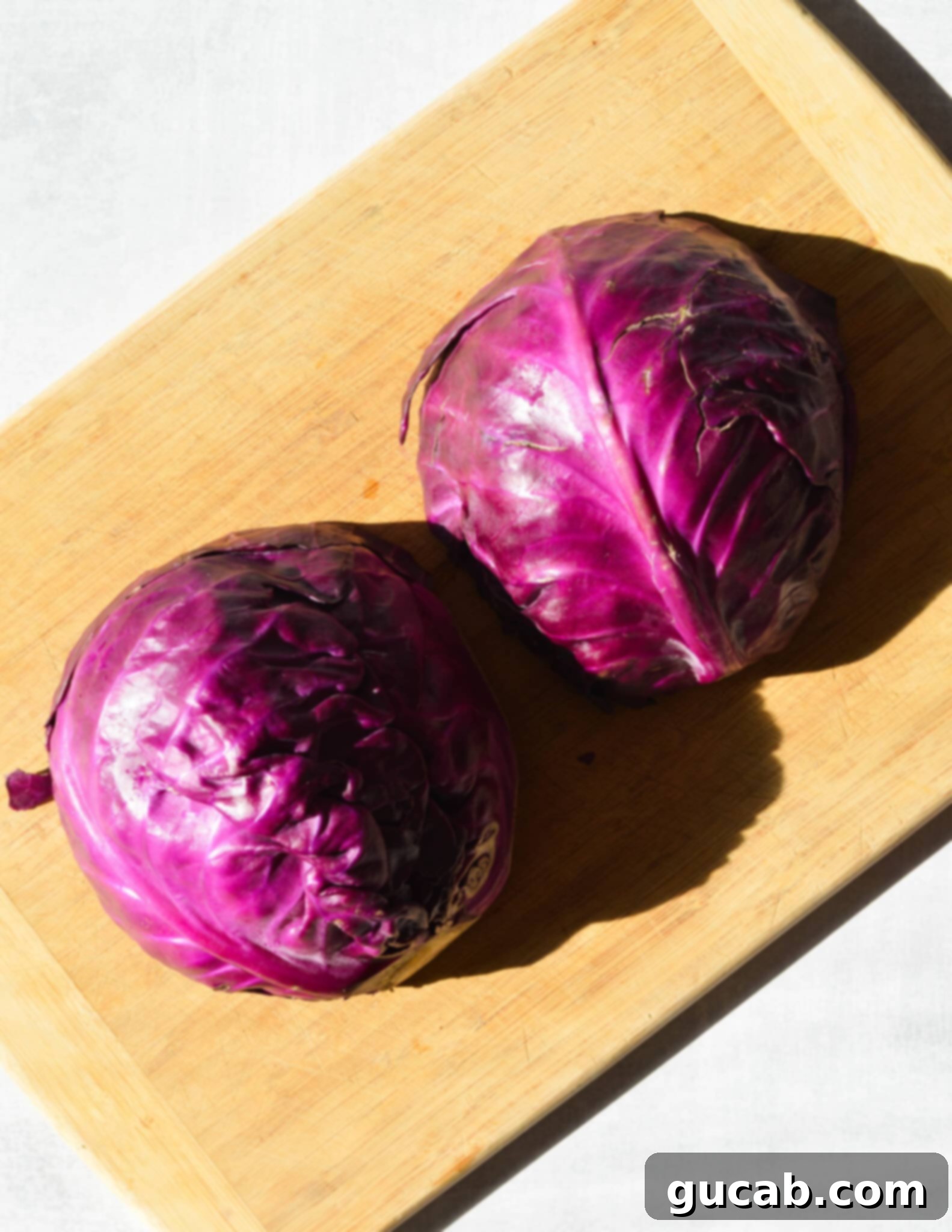 head of cabbage cut in half on cutting board. 