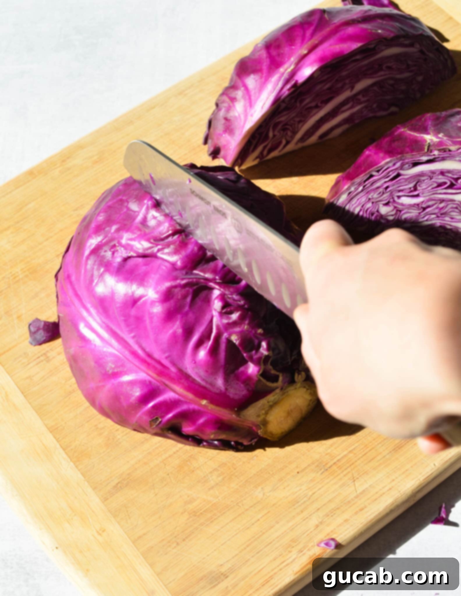 cutting a half of cabbage in half again. 