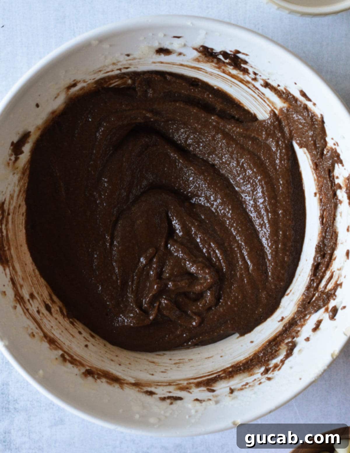 A bowl of creamed butter and sugar with rich melted chocolate added.