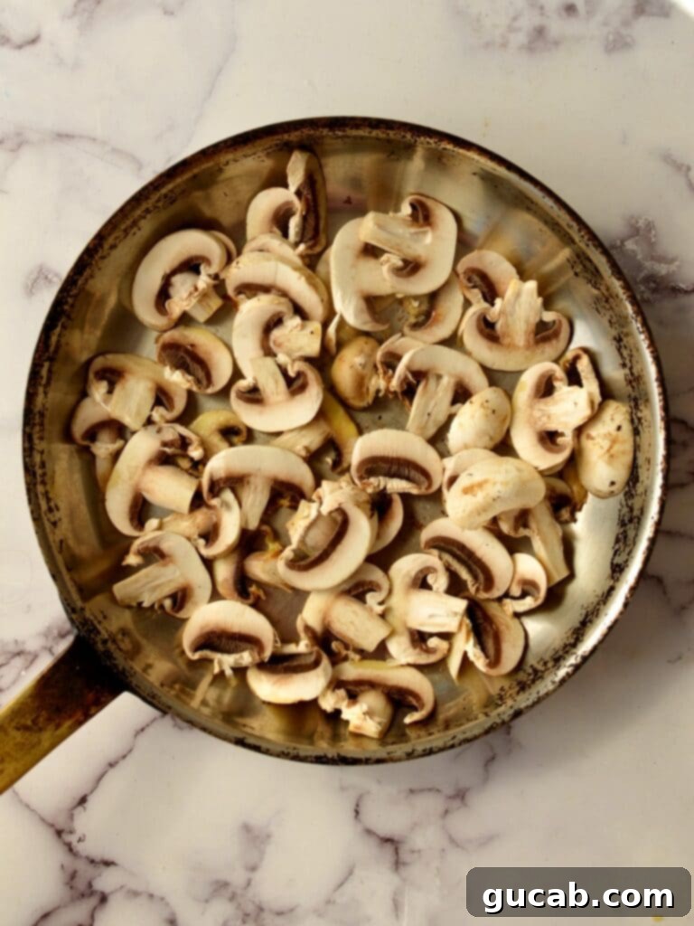 Sweet and Savory Balsamic Glazed Mushrooms 4 Sliced mushrooms browning in a hot stainless steel skillet.