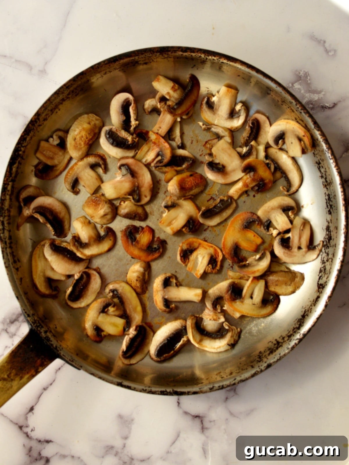 Sweet and Savory Balsamic Glazed Mushrooms 5 Caramelized mushrooms in a pan, showing a rich golden-brown color.