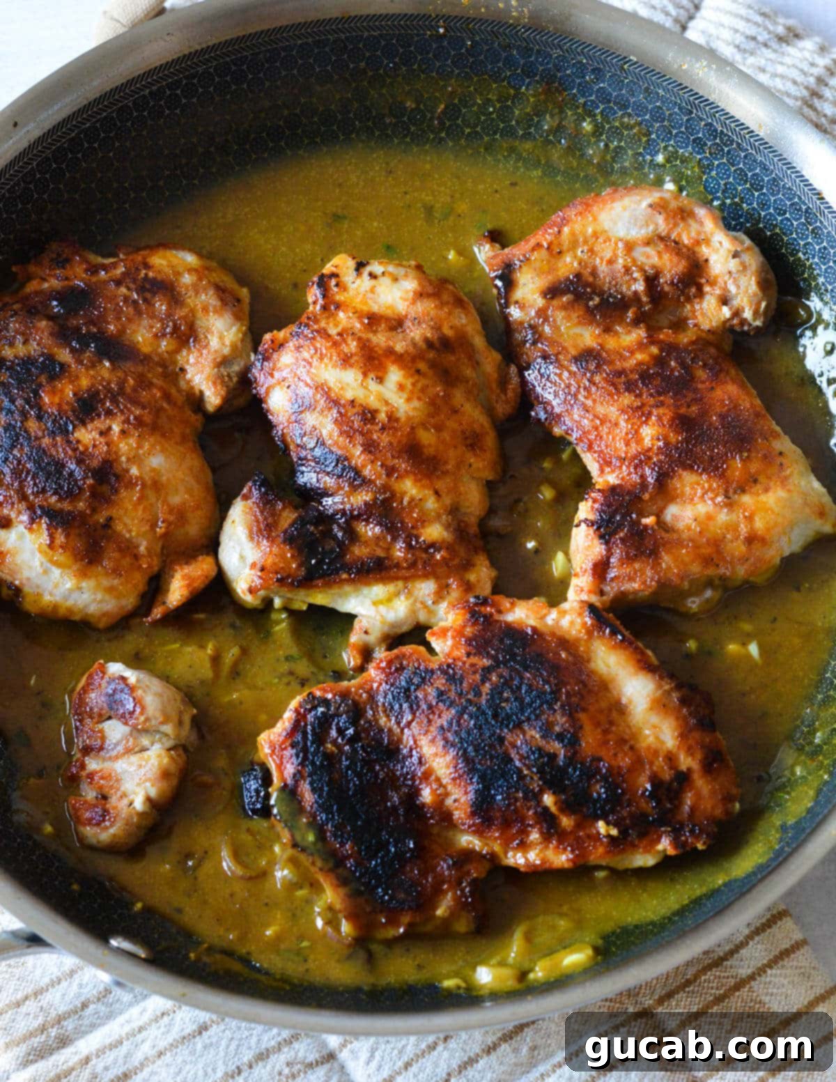 Caramelized chicken thighs nestled back into the skillet, coated in the rich, sweet and tangy mustard sauce.