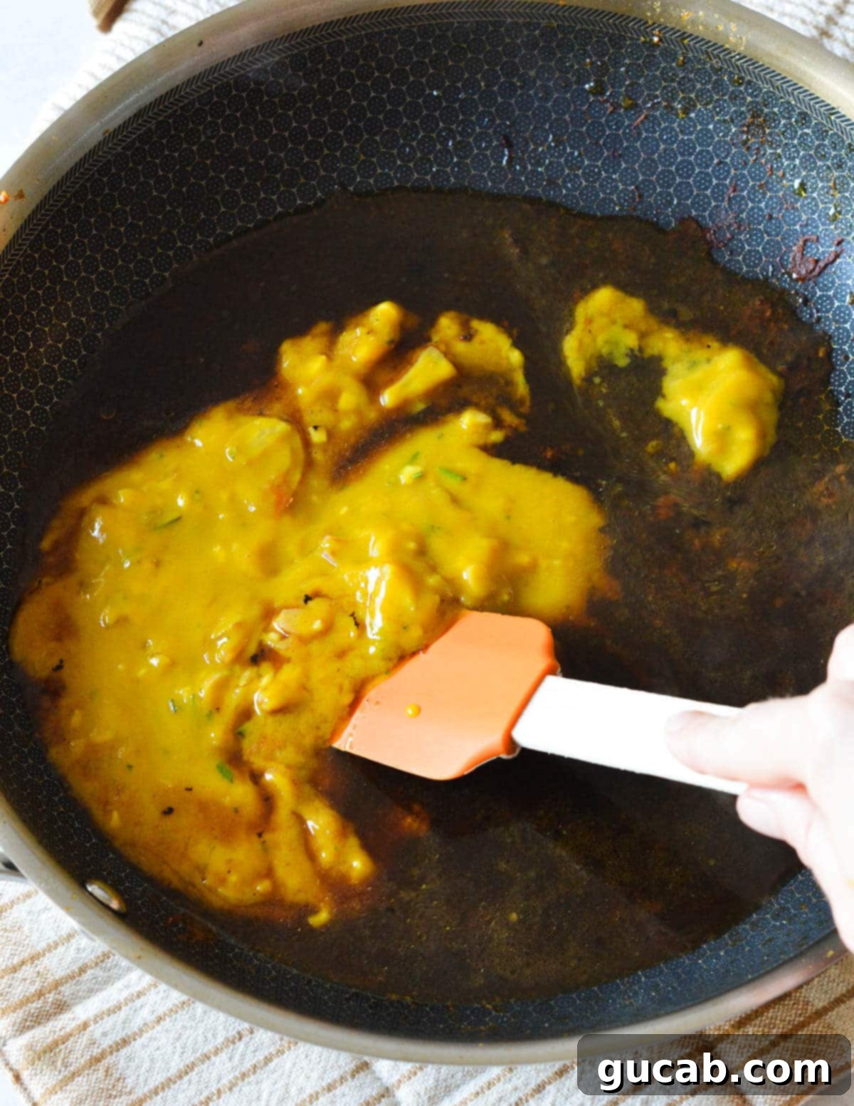 Adding chicken stock to a hot skillet to deglaze the pan, stirring to release caramelized bits from the bottom.