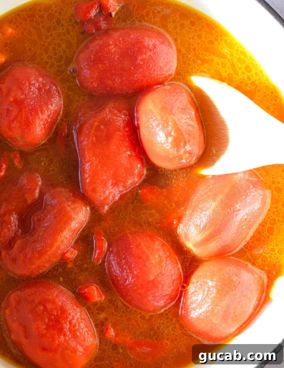 Whole tomatoes, vegetable stock, and roasted red peppers added to the pot.