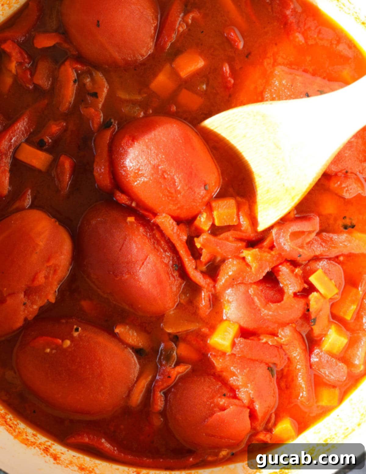 A pot of roasted red pepper soup before it's been pureed, simmering.