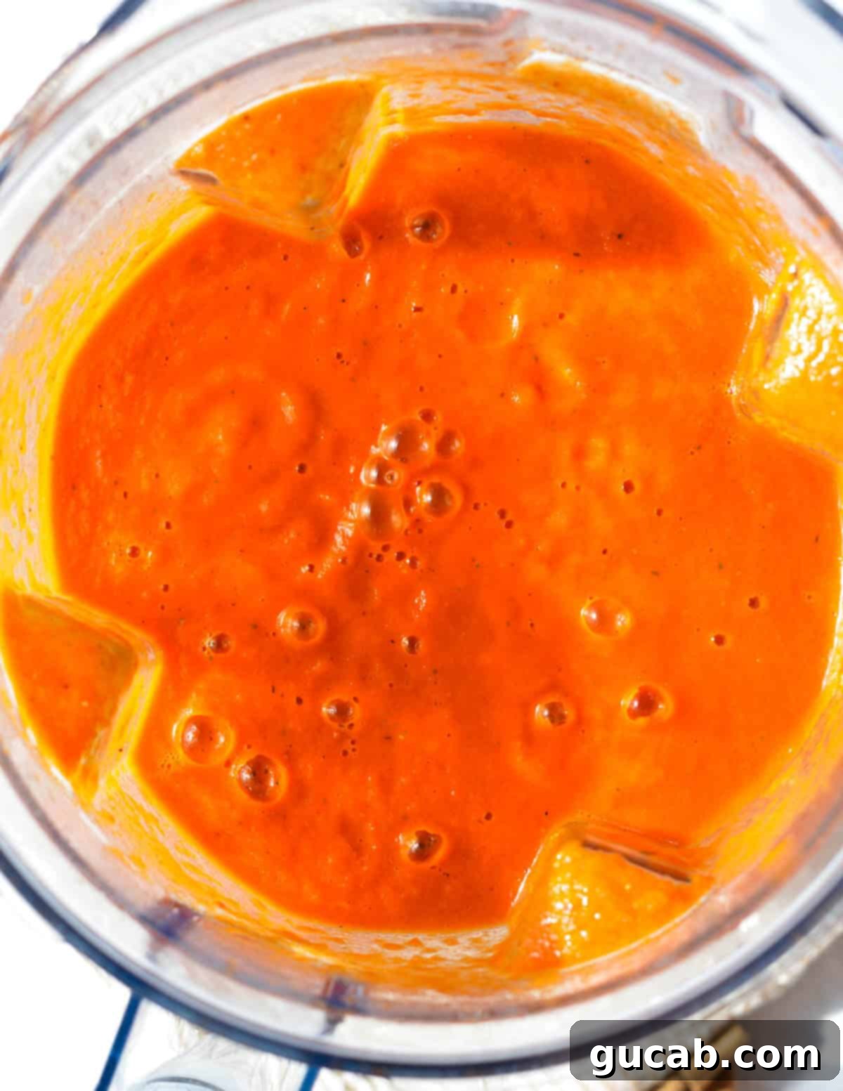 Pureed roasted red pepper soup in a blender, showing its smooth texture.