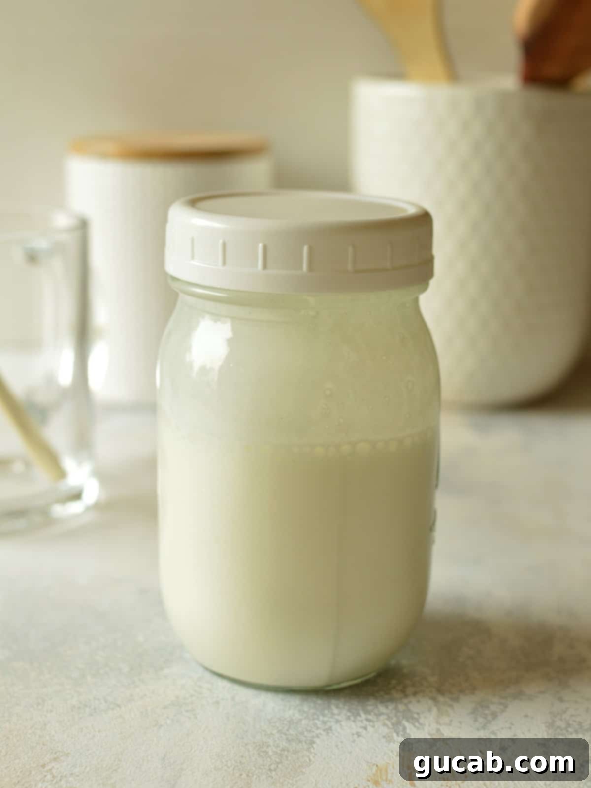A jar filled with fluffy vanilla sweet cream cold foam, showing its whipped texture and readiness to be poured.