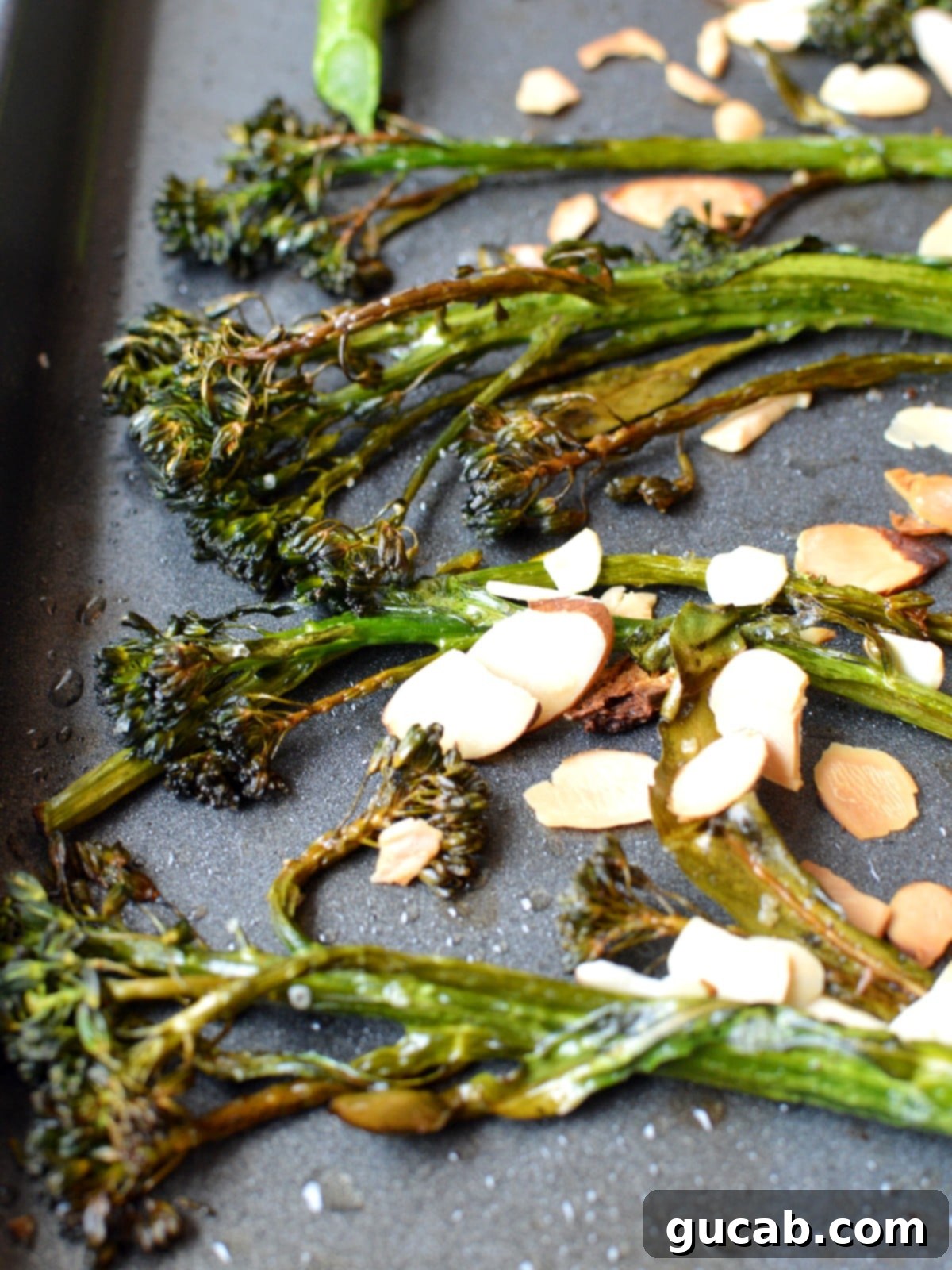 Close-up of perfectly roasted tenderstem broccoli topped with golden sliced almonds.