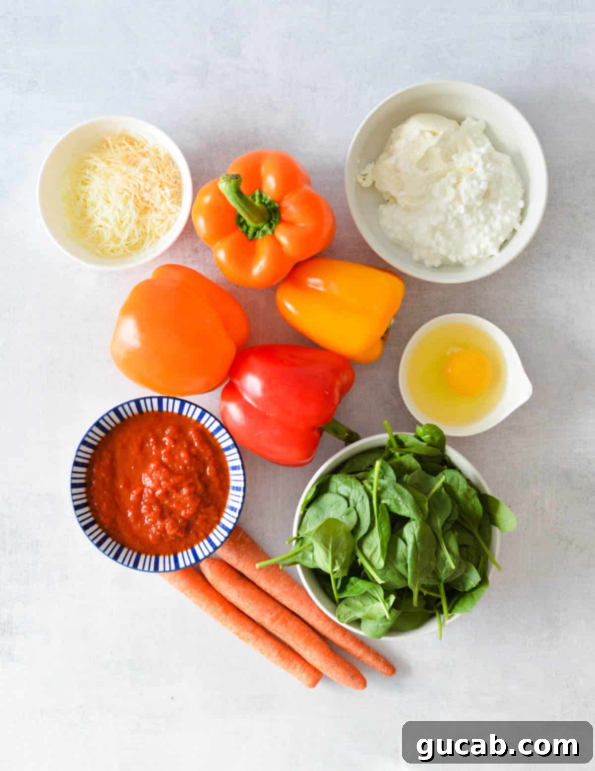 Fresh ingredients laid out for making lasagna stuffed peppers, including bell peppers, cheese, ground beef, and vegetables.