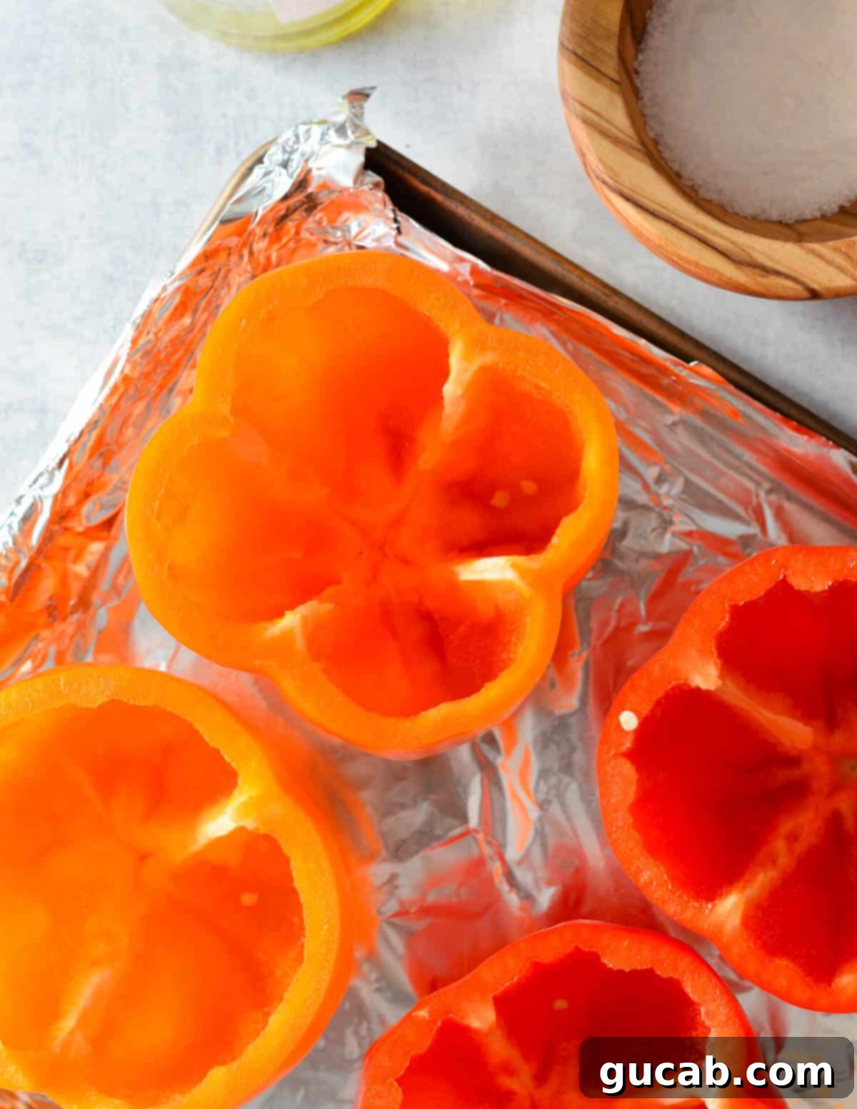 Empty bell peppers with no tops or seeds on a sheet pan, ready for baking.