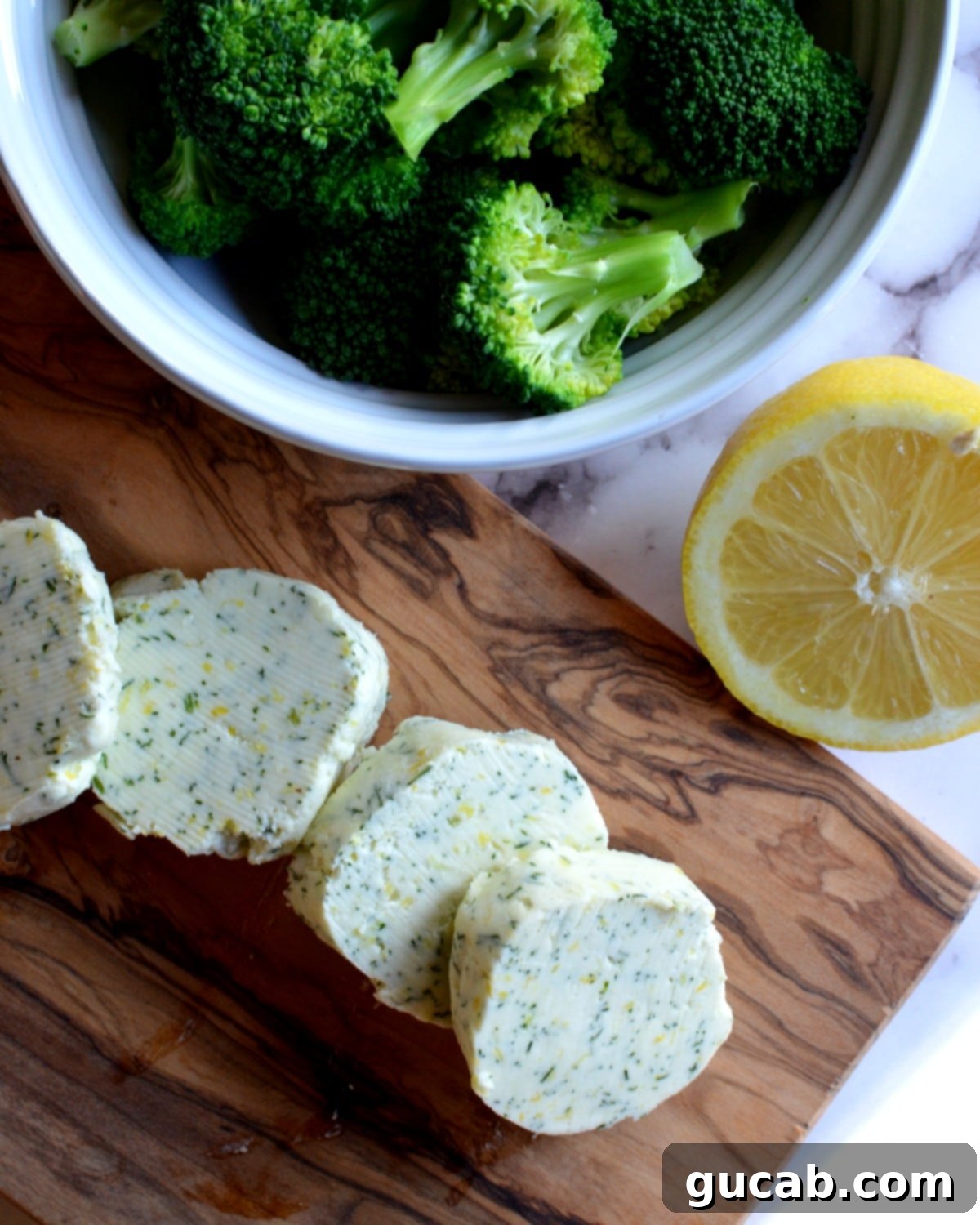 Slices of golden dill butter with vibrant green steamed broccoli, ready to infuse meals with fresh flavor.