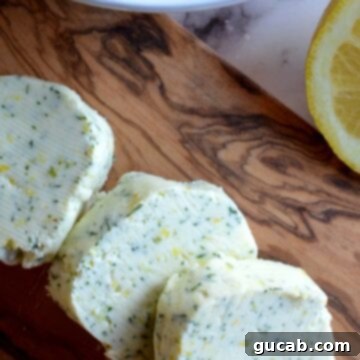 Slices of fresh homemade dill butter on a cutting board, ready to be used in various dishes.