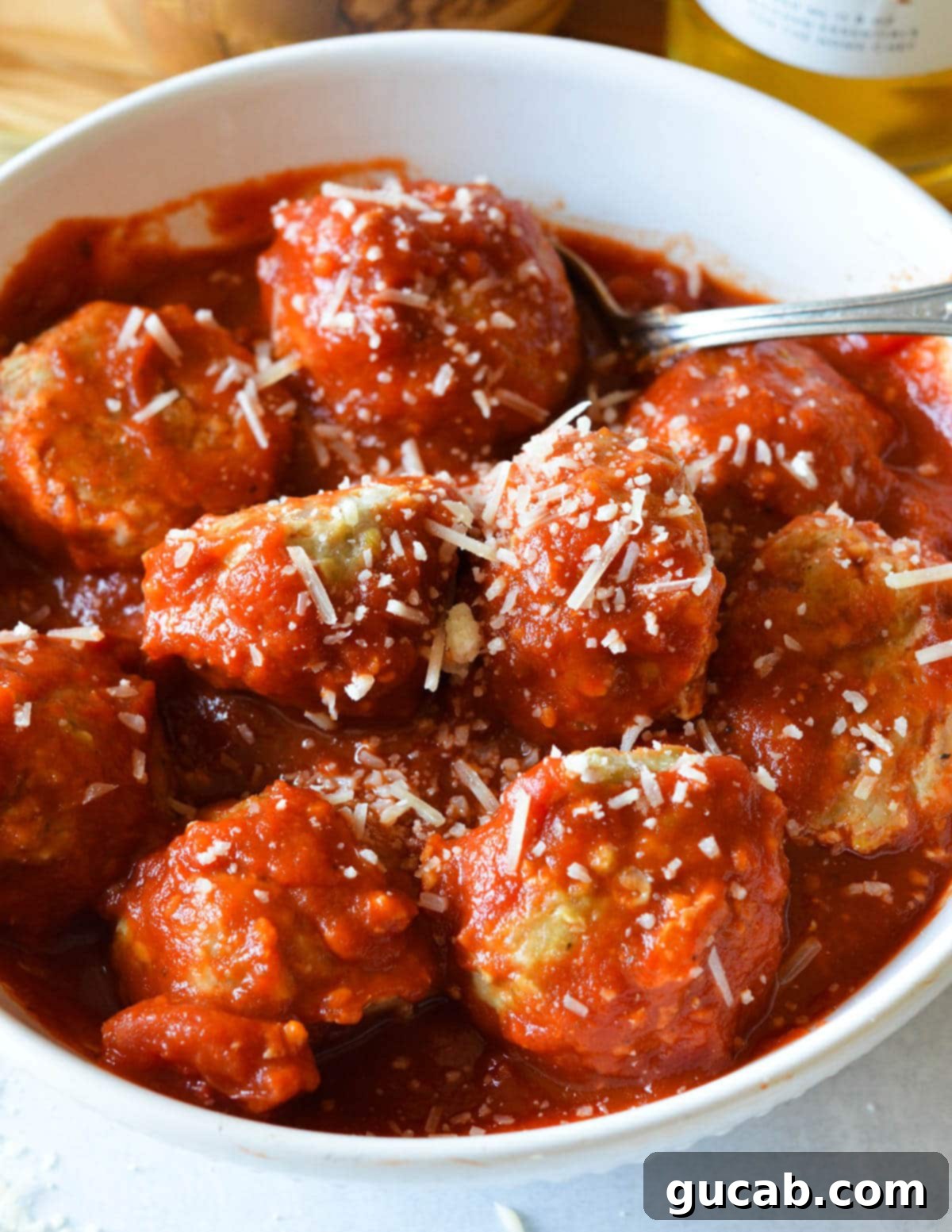turkey meatballs in a bowl with marinara sauce and parmesan on top 